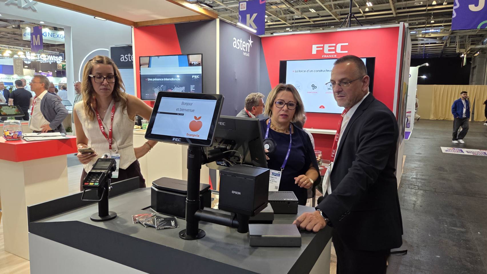 FEC team demoing a POS checkout flow with Franprix branding on screen