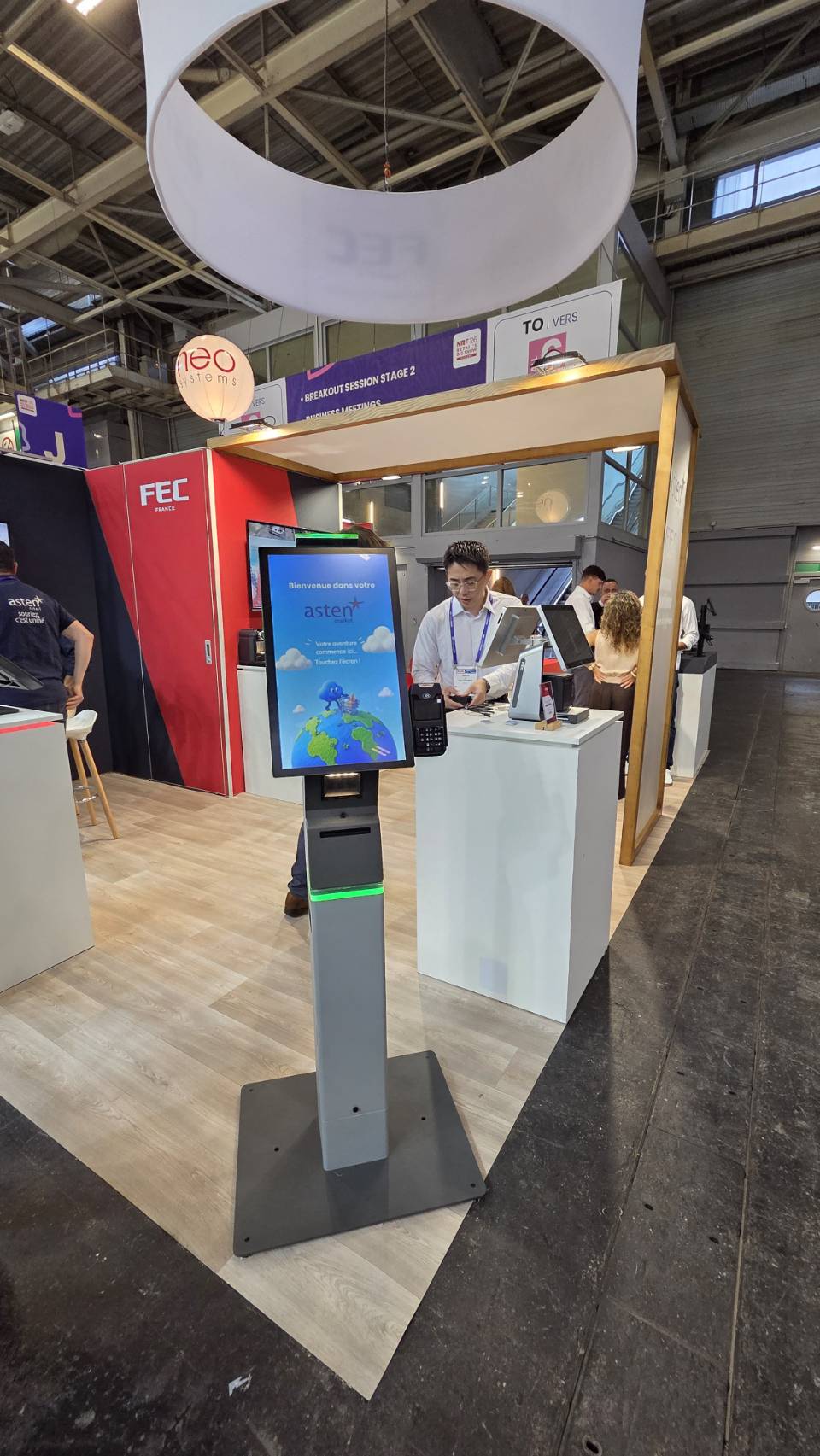 Visitor exploring the Asten Market self-checkout kiosk at the FEC booth